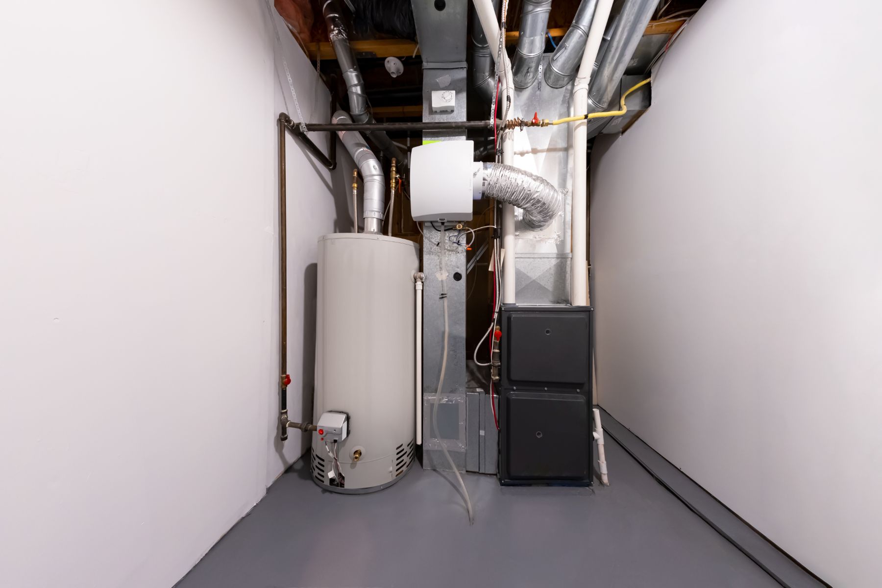 Residential HVAC system with water heater, furnace, and ductwork in utility closet